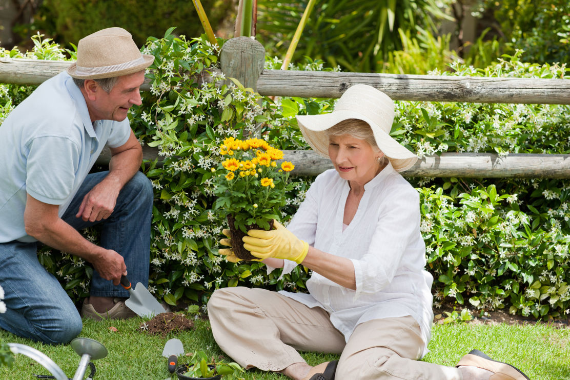 Paar geniesst den Ruhestand im Garten und fragt sich ob sie Ihre Hypothek amortisieren sollen oder nicht.