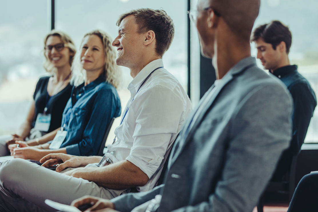 Teilnehmer sitzen im Publikum und nehmen am Kompakt-Seminar teil. 