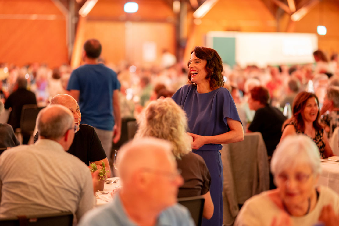 Mona Vetsch überreicht dem Gewinner des TKB-Quiz das Goldvreneli persönlich und scherzt mit den Gästen.